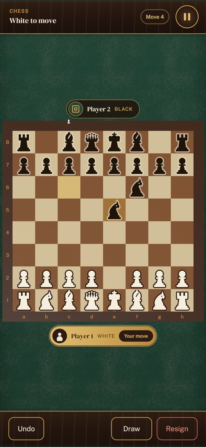 A game of chess in Parlorium: a walnut board on green felt, with brass nameplates for each player.